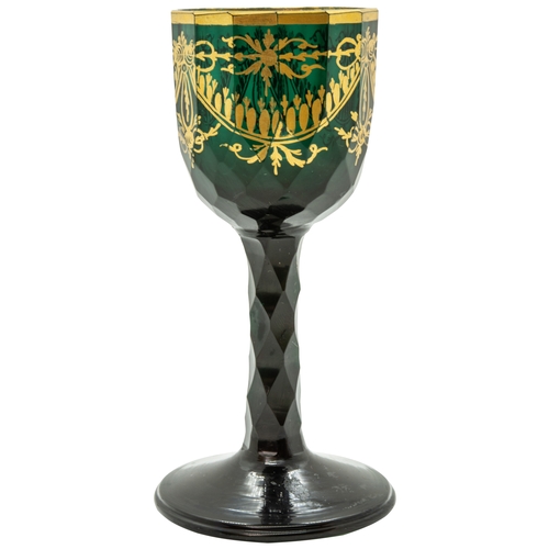 1208 - A GREEN GLASS WITH GILDED DECORATION18TH CENTURYDecorated with gilded sways, raised on a faceted ste... 