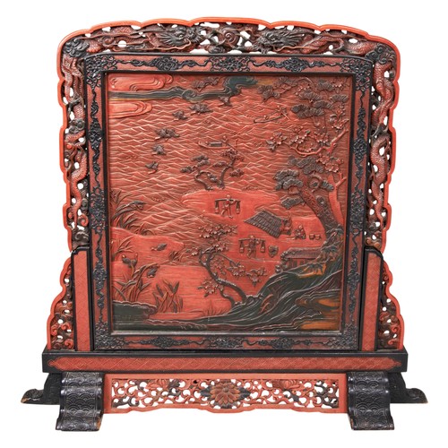 2213 - A JAPANESE CARVED RED AND BLACK SCREEN MEIJI PERIOD carved with figures in a rural river side landsc... 