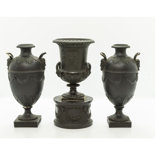 965 - A WEDGWOOD BLACK BASALT CAMPAGNA URN18TH CENTURYTogether with a pair of urns, 17cms high