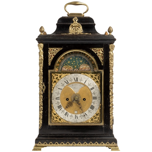 AN EBONY VENEERED STRIKING BRACKET CLOCK. With moon phase and alarm, signed on a recessed plaque in the matted centre Smith and Sons, London, chapter ring with arcaded minutes, the arch with moon phase, foliate engraved backplate in a bell top case flashed by brass caryatids, 48cm.