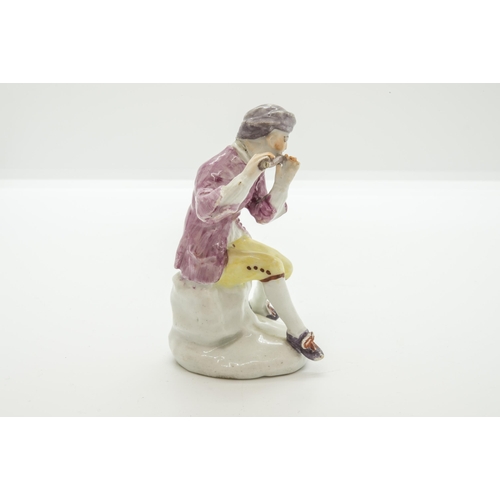 1064 - A MID 18TH CENTURY FIGURE OF A SEATED PIPER, PROBABLY BOWCirca 1755, with square hole for a metal mo... 