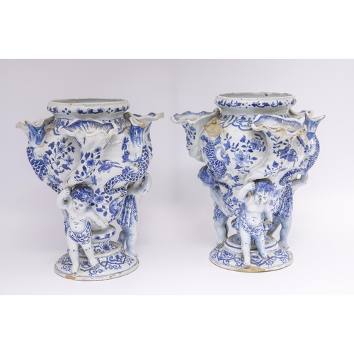 1131 - A PAIR OF DELFT TULIP VASES18th century, three cherubs with cornucopia supporting central vase flank... 