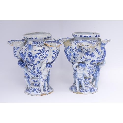 1131 - A PAIR OF DELFT TULIP VASES18th century, three cherubs with cornucopia supporting central vase flank... 