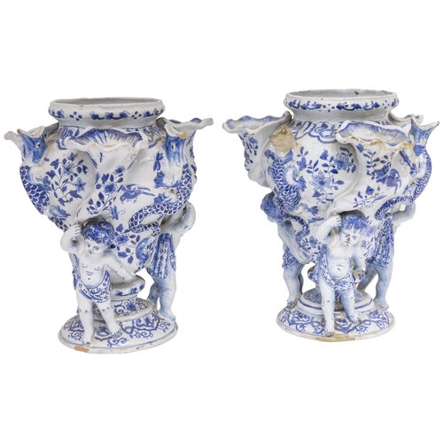 1131 - A PAIR OF DELFT TULIP VASES18th century, three cherubs with cornucopia supporting central vase flank... 