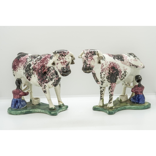 1154 - A PAIR OF SPONGED COW CREAMERSCirca 1840, with attendant milk maids on wafer bases, 19cms long