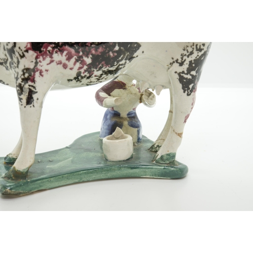 1154 - A PAIR OF SPONGED COW CREAMERSCirca 1840, with attendant milk maids on wafer bases, 19cms long