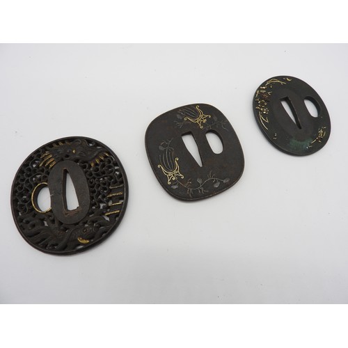 2224 - A RETICULATED JAPANESE IRON TSUBA decorated with a dragon in a stylised sky, a pagoda and a fish, an... 