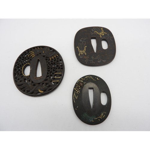 2224 - A RETICULATED JAPANESE IRON TSUBA decorated with a dragon in a stylised sky, a pagoda and a fish, an... 