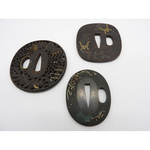 2224 - A RETICULATED JAPANESE IRON TSUBA decorated with a dragon in a stylised sky, a pagoda and a fish, an... 