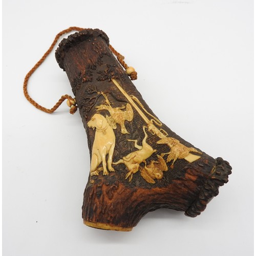 656 - A 19TH CENTURY STAG HORN POWDER FLASK, probably German, intricately carved with a hunting dog, rifle... 