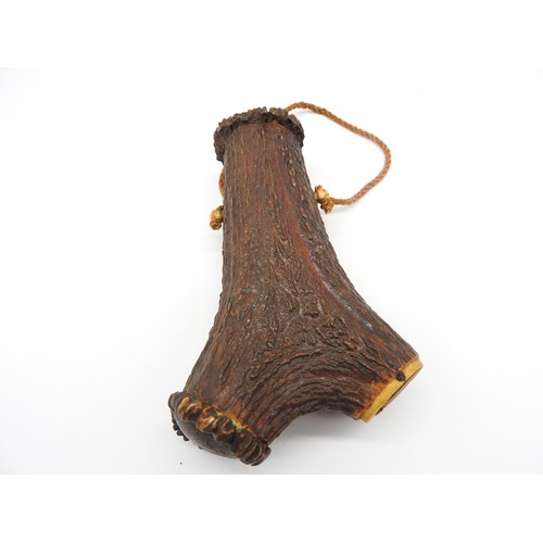 656 - A 19TH CENTURY STAG HORN POWDER FLASK, probably German, intricately carved with a hunting dog, rifle... 