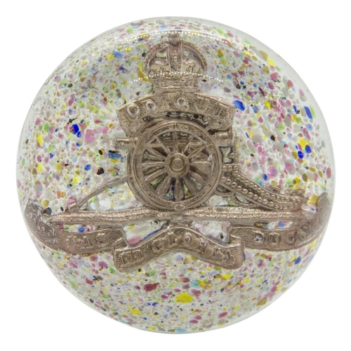 673 - A ROYAL ARTILLERY GLASS PAPERWEIGHT with RA cap badge on a mottled background with rough broken pont... 