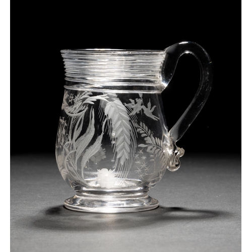 1276 - A GOOD 18TH CENTURY GLASS TANKARD, engraved with hops and an initialled cartouche with applied strun... 