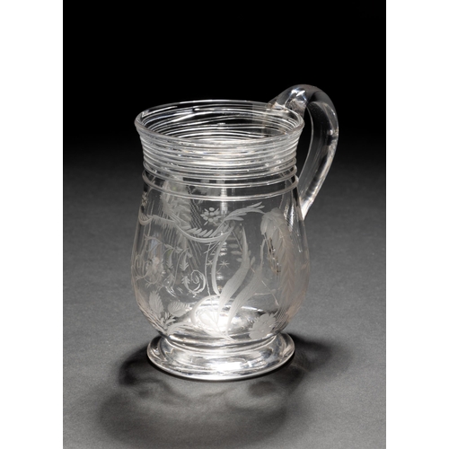 1276 - A GOOD 18TH CENTURY GLASS TANKARD, engraved with hops and an initialled cartouche with applied strun... 