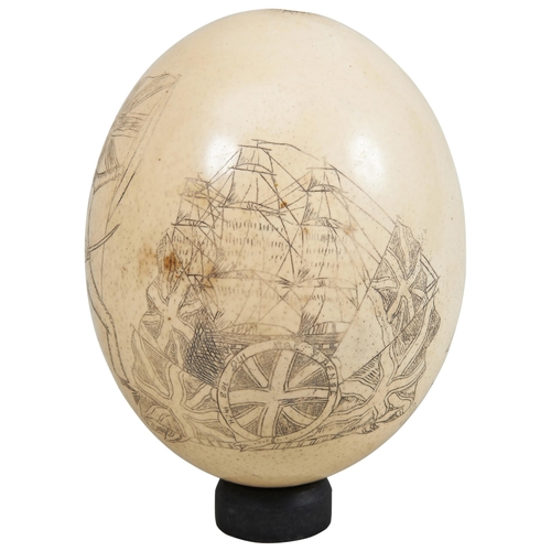 1784 - A SCRAFITTO DECORATED OSTRICH EGG DEPICTING A SAILOR WITH SWORD and a naval ship with a stand of fla... 