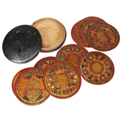 A RARE SET OF TWELVE ELIZABETHAN CIRCULAR SYCAMORE TRENCHERS, each one painted with a central verse and naturalistic floral and foliate borders contained in a turned wooden lacquered box with pen inscription ‘R Mantell’ .