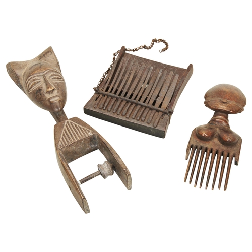 1348 - A HEDDLE PULLEY WITH STYLISED FEMALE HEAD, A Yoruba wooden comb, the handle carved as a female torso... 