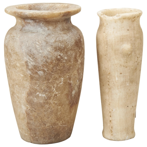 1321 - AN ANCIENT EGYPIAN ALABASTER JAR OF ELONGATED TAPERING FORM WITH TWO 'LUGS'. The flared rim partly c... 