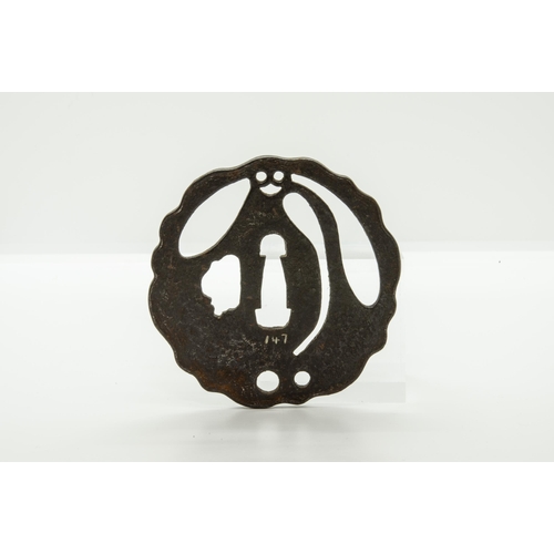 2226 - A JAPANESE IRON TSUBA decorated with a dragon ‘piercing’ the plane of the guard, a finely reticulate... 