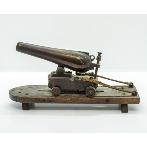 708 - A MODEL OF A VICTORIAN BATTERY GUN the cast barrel upon a rolling carriage mounted on a platform bas... 