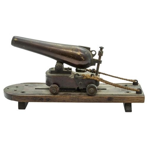 708 - A MODEL OF A VICTORIAN BATTERY GUN the cast barrel upon a rolling carriage mounted on a platform bas... 