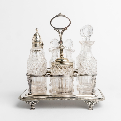 455 - A GEORGE III SEVEN BOTTLE CRUET FRAME, LONDON 1814 An oblong frame with gadroon edge on four paw fee... 