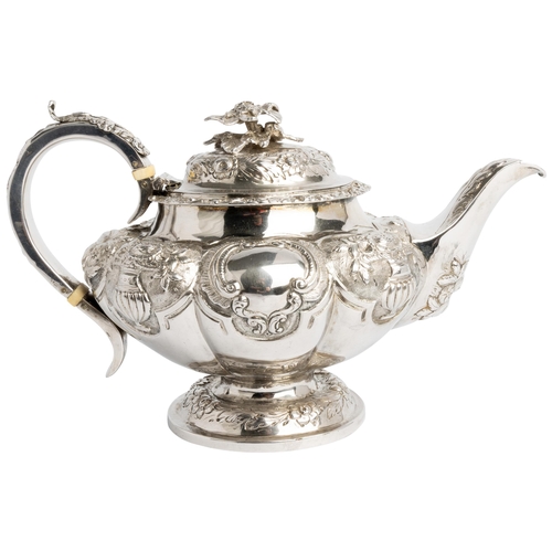 505 - AN EMBOSSED LOBED TEAPOT, LONDON 1838 With silver handle and cast flower finial.26 cm.699 g.Ivory Ex... 