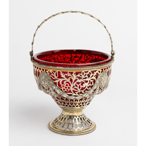 520 - A PIERCED SILVER-GILT SWING HANDLE SUGAR VASE, LONDON 1903 With a ruby glass liner.12.8 cm dia.230 g... 