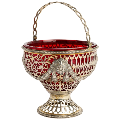 520 - A PIERCED SILVER-GILT SWING HANDLE SUGAR VASE, LONDON 1903 With a ruby glass liner.12.8 cm dia.230 g... 