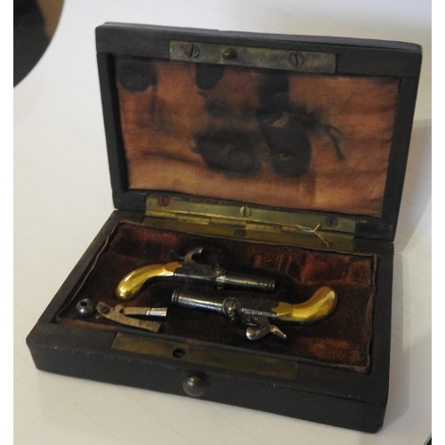 631 - A CASED 19TH CENTURY PAIR OF MINIATURE PERCUSSION PISTOLS with engraved decoration, drop down trigge... 