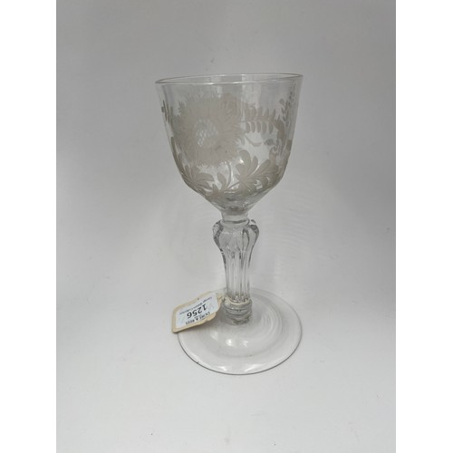 1256 - AN ENGRAVED 18TH CENTURY WINE GLASSCirca 1750, the engraved bowl raised on a faceted stem, 19cms hig... 