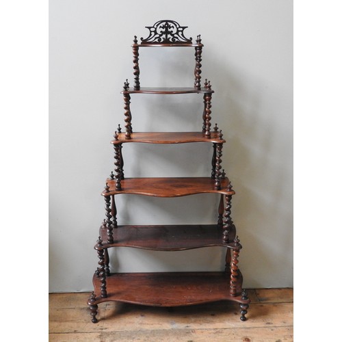 30 - A VICTORIAN ROSEWOOD WHATNOT, consisting of six graduated serpentine shelves united by barley twist ... 