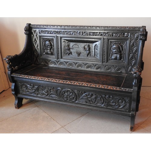 106 - A CARVED OAK SETTLE, LATE 19TH CENTURY, the low back panel carved with a central tavern scene panel ... 