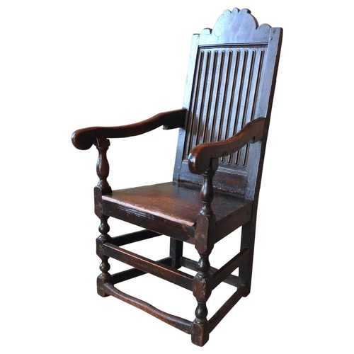 77 - A CHARLES II OAK WAINSCOT CHAIR, carved arch top rail above an unusual reeded back panel with scroll... 