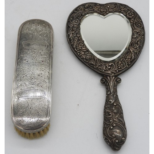 507 - A SILVER MOUNTED HEART SHAPED HAND MIRROR AND AN ORNATE NIELLO DECORATED BRUSH, the mirror with scro... 