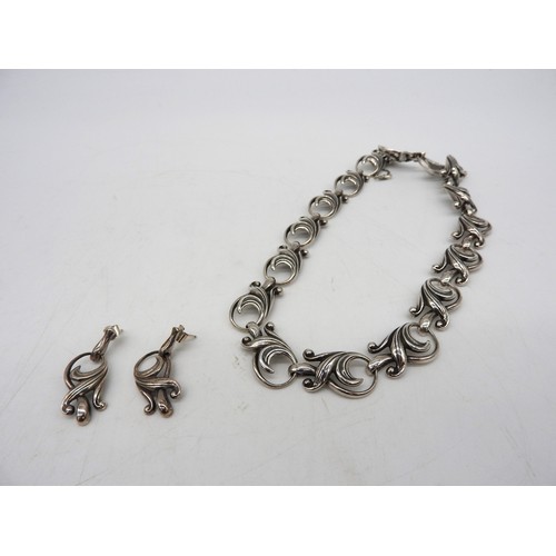 569 - A SILVER NECKLACE AND MATCHING EARRINGS, in an elegant scrolling foliate formChain 43 cm longCombine... 