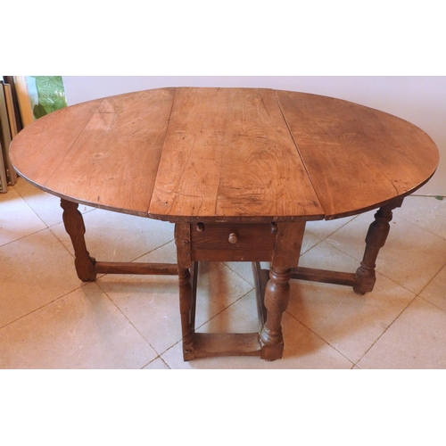 86 - AN EARLY 18TH CENTURY CONTINENTAL OAK GATE-LEG TABLE, hinged oval top over a single end frieze drawe... 