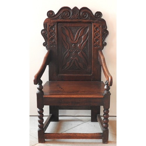 76 - A LATE 17TH CENTURY WAINSCOT CHAIR, scroll carved top rail and ears above a carved panel back, the i... 