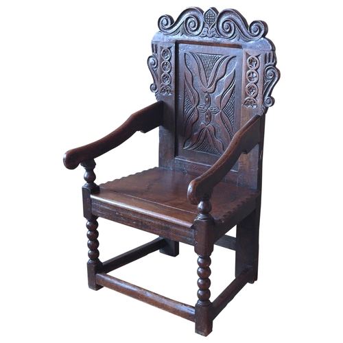 76 - A LATE 17TH CENTURY WAINSCOT CHAIR, scroll carved top rail and ears above a carved panel back, the i... 