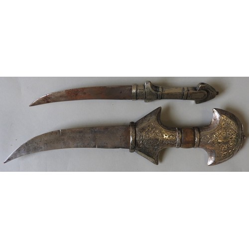 205 - A LARGE AND ORNATE JAMBIYA WITH WHITE METAL HILT AND CURVED SCABBARD AND ANOTHER JAMBIYA.45 cms max... 