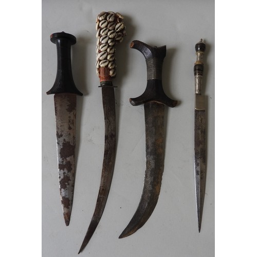 206 - A NORTH AFRICAN JAMBIYA WITH TOOLED LEATHER SCABBARD, A NORTH AFRICAN DAGGER WITH COWRIE SHELL DECOR... 