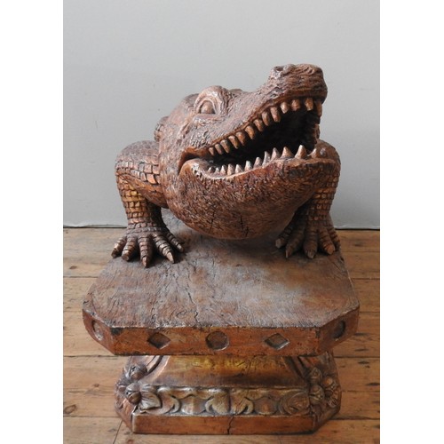 502 - A LARGE CARVED WOODEN DECORATIVE MODEL OF AN ALLIGATOR, standing foursquare on a foliate carved octa... 