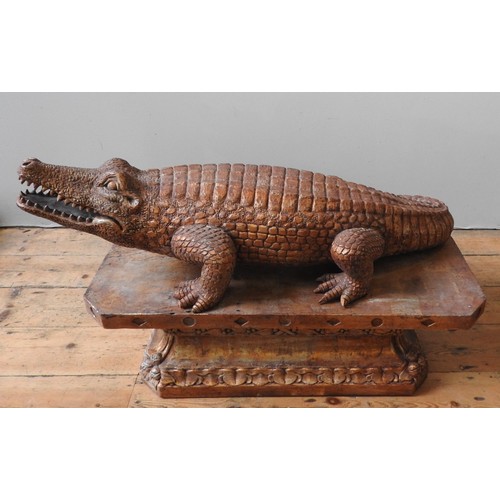 502 - A LARGE CARVED WOODEN DECORATIVE MODEL OF AN ALLIGATOR, standing foursquare on a foliate carved octa... 