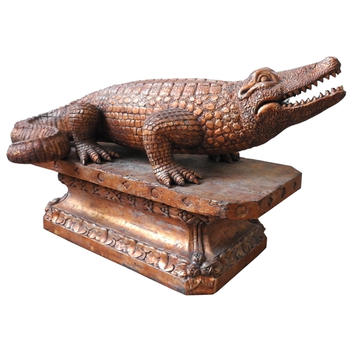 502 - A LARGE CARVED WOODEN DECORATIVE MODEL OF AN ALLIGATOR, standing foursquare on a foliate carved octa... 