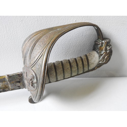 195 - A NAVAL OFFICERS SWORD WITH LIONS HEAD POMMEL and shagreen wired grip the heavily oiled blade with e... 