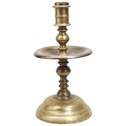 180 - A LARGE 17TH CENTURY BRASS MID-DRIP CANDLESTICK WITH CONCENTRIC KNOPS AND LINES.Old repairs to base.... 