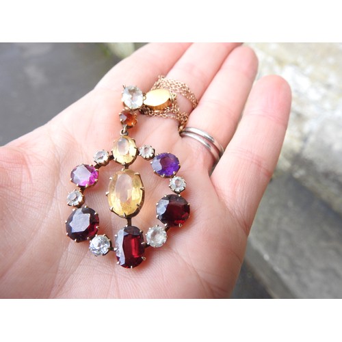 521 - AN EDWARDIAN GEM SET YELLOW METAL PENDANT set with amethyst, quartz and garnet. Chain broken.