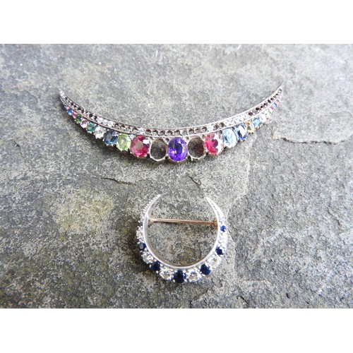 534 - A SMALL DIAMOND AND SAPPHIRE CRESCENT SHAPED BROOCH set in yellow and white metal and a multi gem se... 