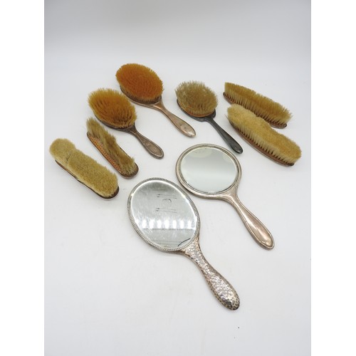 524 - A GROUP OF TWO SILVER HAND MIRRORS AND SEVEN SILVER MOUNTED BRUSHES, various styles including an ena... 