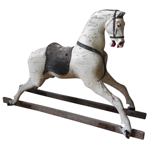 501 - A LARGE VINTAGE CARVED WOODEN ROCKING HORSE, cream painted with a leather saddle, missing the trestl... 